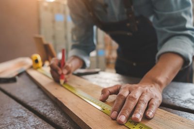 Tischlergeselle bei der Arbeit in der Holz-Werkstatt.