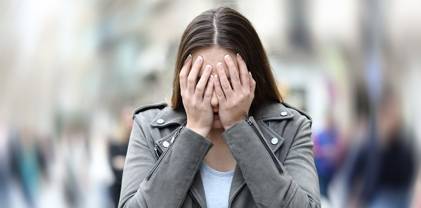 Frau auf öffentlichem Platz leidet an starker Angst.