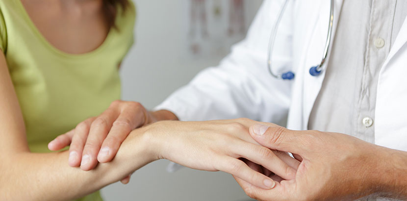 Frau zeigt Rheumatologen ihre entzündete Hand