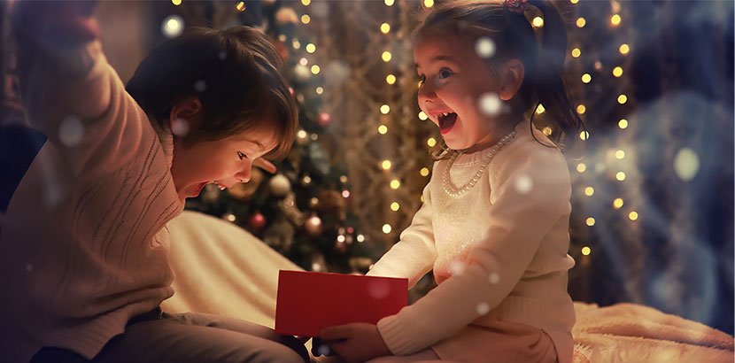 funkelnde Kinderaugen beim Öffnen eines Weihnachtsgeschenks