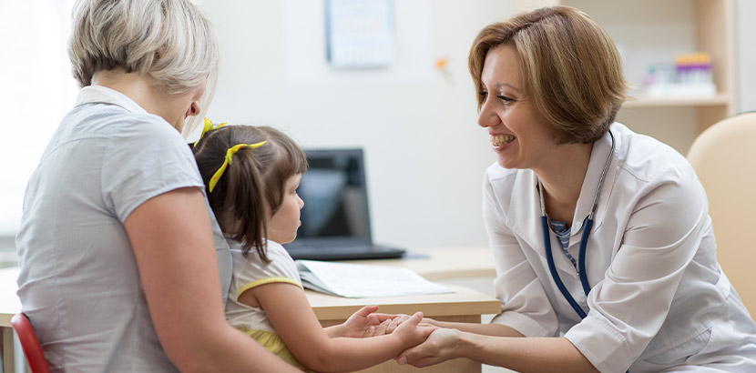 Mutter und Tochter bei Termin in Kinderarztpraxis.