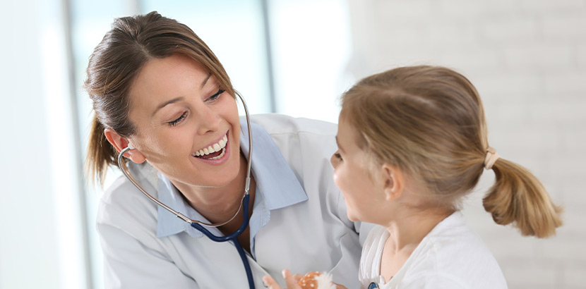 Junges Mädchen und lächelnde Ärztin bei Untersuchung.