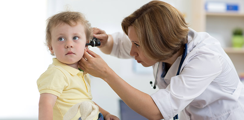 Hals-Nasen-Ohren-Ärztin untersucht Kind mit entzündeten Ohren bei Diagnose.