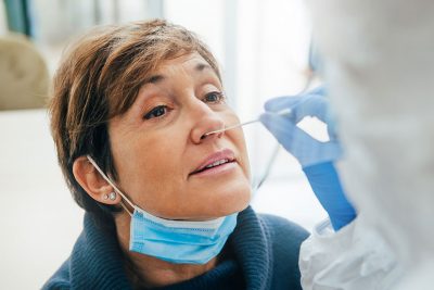 Arzt verwendet Nasenabstrich bei Patienten für Covid-Test.