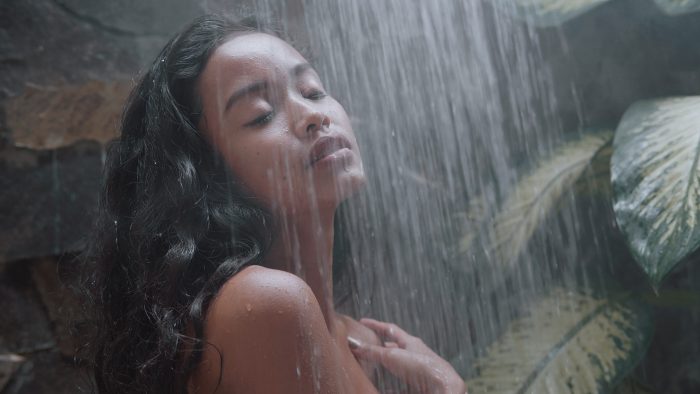 attraktive exotische Frau duscht in einer Regendusche