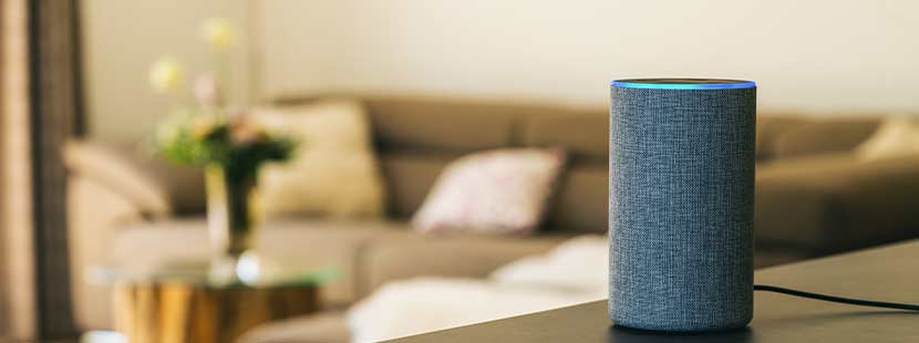 Smart Speaker, der in einem Wohnzimmer auf dem Tisch steht und auf Voice Search optimiert ist.
