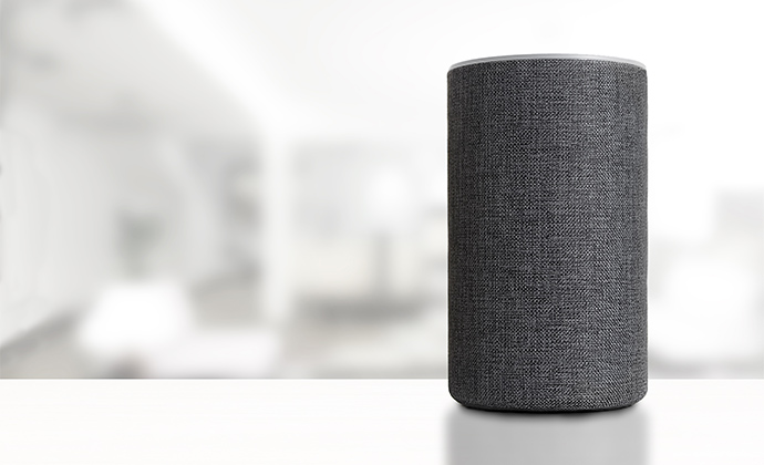 Amazon Smart Speaker, der in einem Wohnzimmer auf dem Tisch steht und Antworten sowie Ergebnisse liefert.