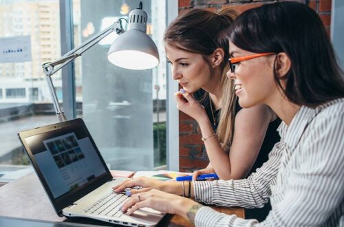 Zwei Frauen wählen Website Programme, die sie für das Entwickeln einer Homepage verwenden.