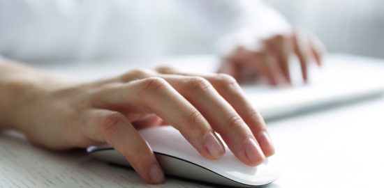Frau mit Maus in der Hand klickt auf eine Suchmaschinenwerbung