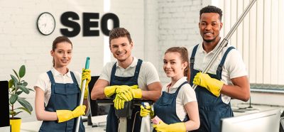 Reinigungskräfte mit SEO-Schriftzug im Hintergrund symbolisieren die Notwendigkeit von SEO für Reinigungsfirmen