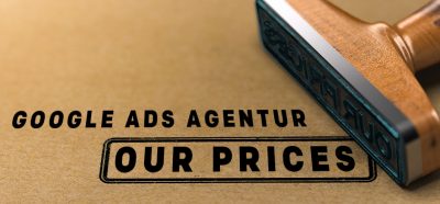 "Google Ads Agentur: Our Prices"-Schriftzug neben Stempel