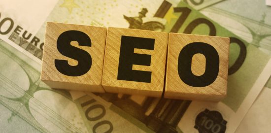 SEO-Schriftzug mit Geldscheinen im Hintergrund symbolisieren SEO Kosten.