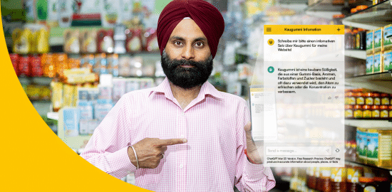 Bild zeigt Beistzer eines indischen Supermarktes, der auf sein Smartphone zeigt, mit dem er Chat GPT nutzt