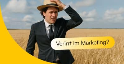 Anwalt, der suchend im Weizenfeld steht. Neben ihm der Satz "Verirrt im Marketing?"